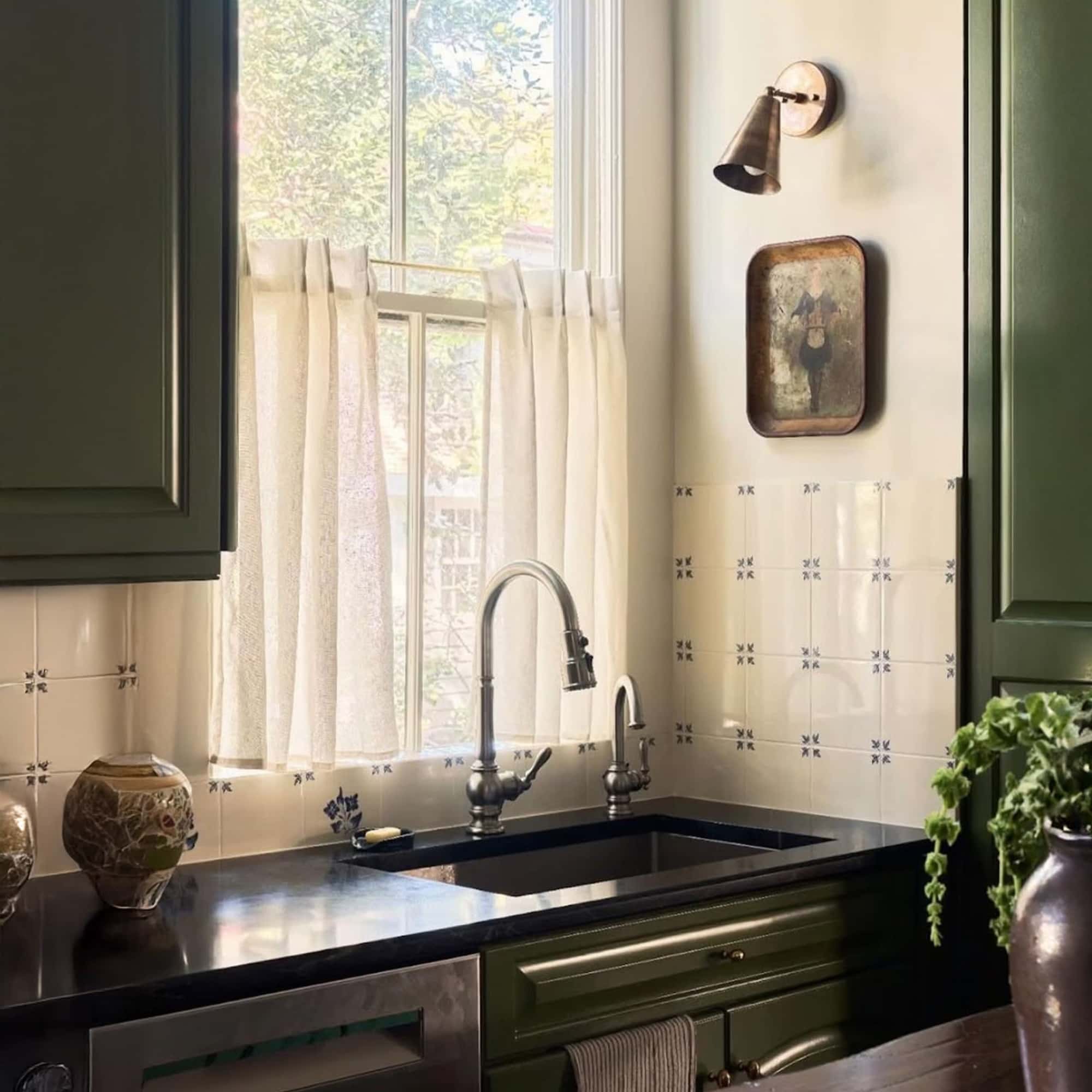 hand painted ceramic tile backsplash with black kitchen countertops