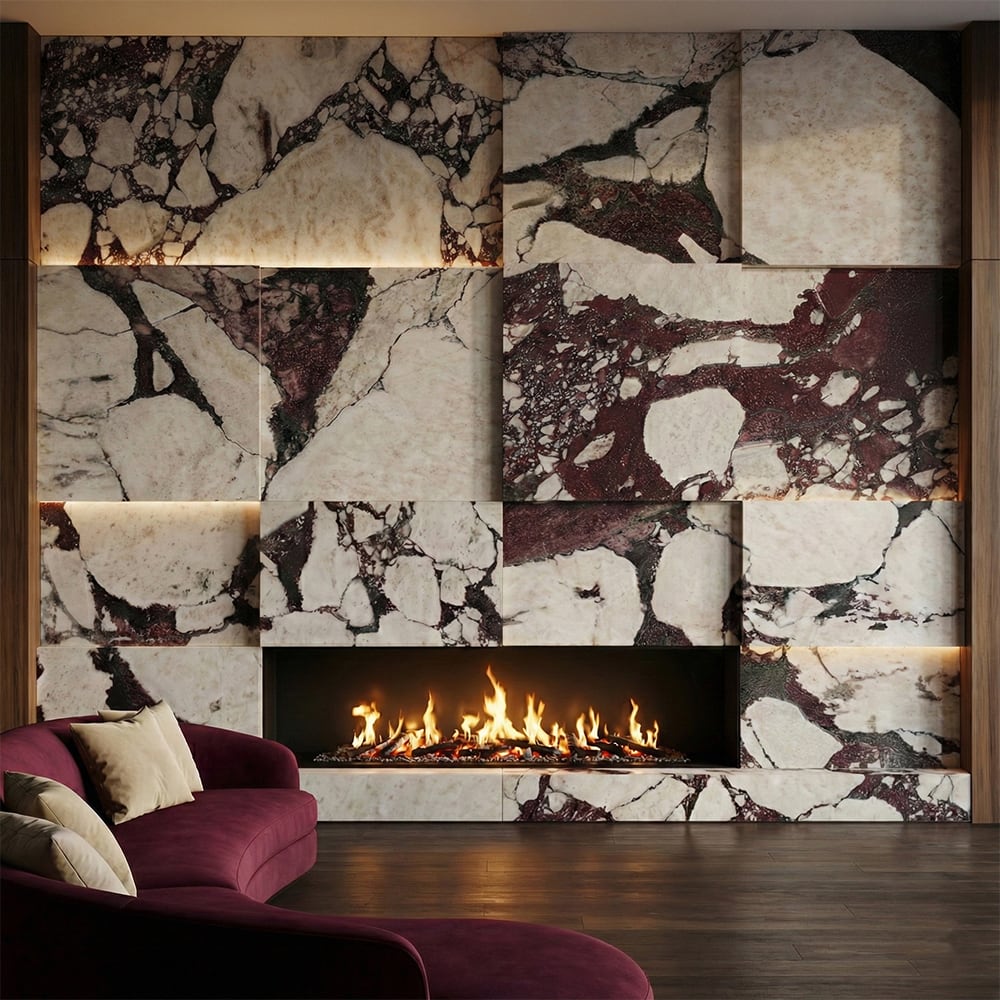 Calacatta viola marble slab fireplace surround in large format mixed panel layout with dramatic burgundy red and white veining variation across full wall, linear gas fireplace insert, dark wood floor, burgundy velvet curved sofa and warm ambient LED lighting